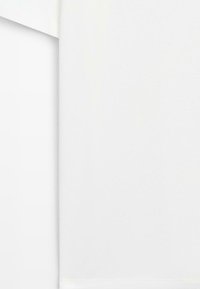 Deux serviettes en tissu blanches pliées empilées sur une surface blanche, montrant des bords nets et une texture de tissu lisse.