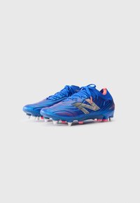 Blue synthetic soccer cleats feature a textured upper with a gradient design, silver accents, and white studs on the sole.