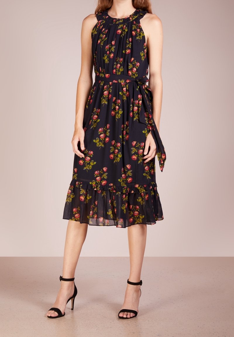 Schwarzes Blumenkleid mit Halterneck, Ausschnitt-Detail, leuchtend pinken Rosen und grünen Blättern, gerafftem Saum und passendem Taillengürtel.