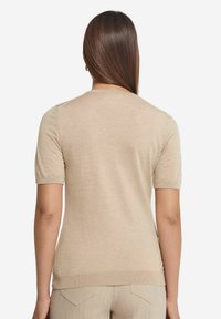 Beżowy sweter z krótkim rękawem i okrągłym dekoltem, gładka tekstura, ściągacze przy rękawach i u dołu, prezentowany z tyłu. Minimalistyczny design.