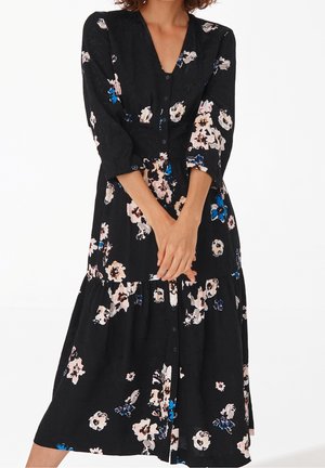 Robe noire à motifs floraux avec décolleté en V, manches trois-quarts, boutons frontaux, bas à volants et motifs floraux pastel roses et bleus.
