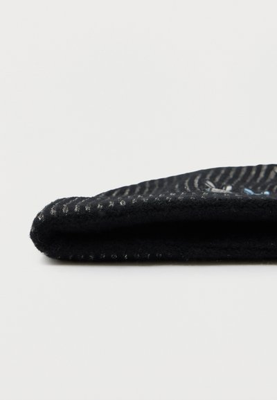 Chausson en feutre noir avec une texture lisse, présentant une forme arrondie et une couture discrète le long du bord. Design simple sans accents supplémentaires.