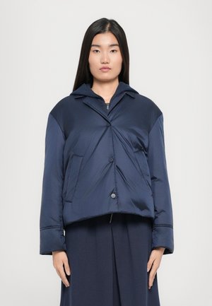 Marineblaue Pufferjacke mit einem kurzen Design, Knopfverschluss, großem Kragen und Seitentaschen, mit einer glatten, glänzenden Textur.
