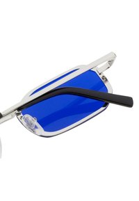 Occhiali da sole con lenti blu e montatura argentata elegante con asta nera. Il design è angolare e moderno, con una finitura lucida.