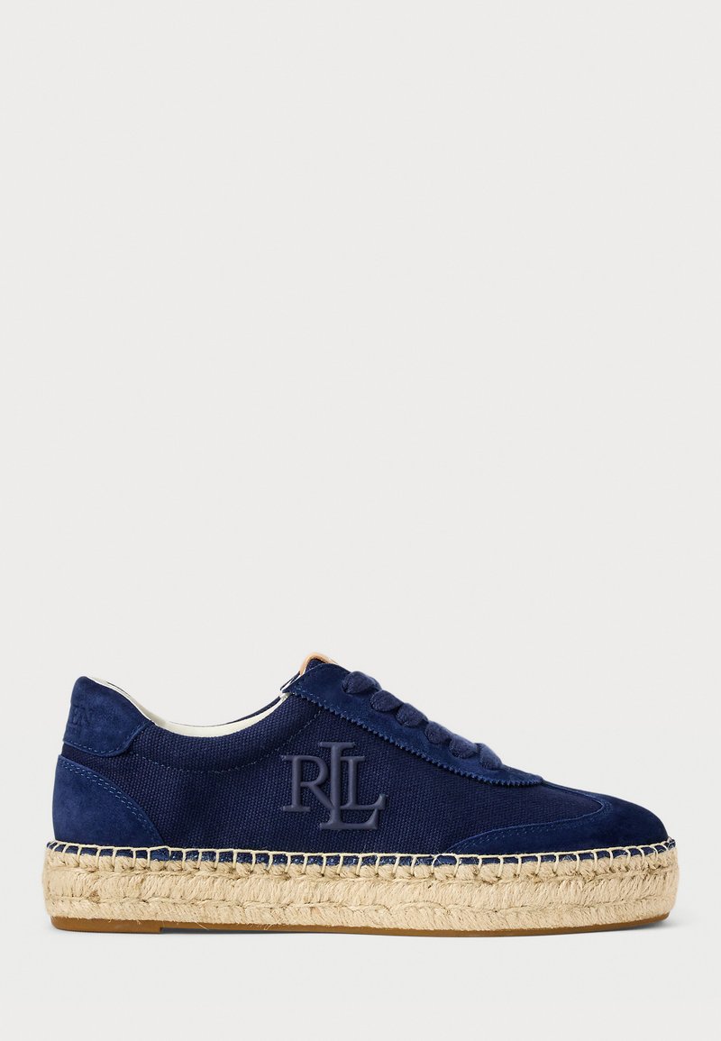 Zapatillas de color azul marino con parte superior de ante y lona, punta redonda, cordones en la parte delantera y suela envuelta en yute. Presenta un logo grabado en el lateral.
