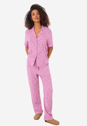 Pigiama con maniche corte e bottoni, di colore rosa, con un intricato motivo paisley. I pantaloni sono morbidi e dotati di una cintura elastica.