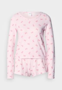 Ροζ πιτζάμα με μακριά μανίκια και σχέδια με φιόγκους. Απαλό ύφασμα, στρογγυλή λαιμόκοψη και ταιριαστά σορτς με ελαστική μέση.