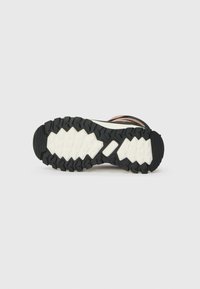 Gumijas zole ar daudzvirzienu saķeres rakstu, ar melnu virsmu un baltu vidusdaļu, izstrādāta āra izturībai un saķerei.