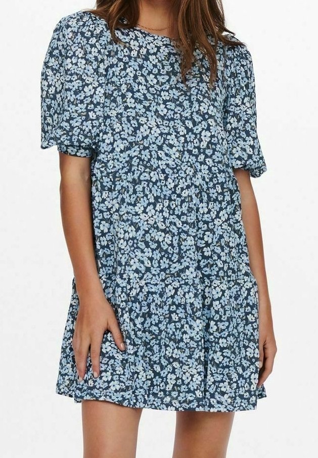 Květinové šaty v námořnické modři s krátkými vyp puff rukávy, představující jemný světle modrý květinový vzor a design sukně ve vrstvách. Měkká látka.