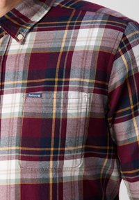 Chemise à boutons à carreaux avec des rayures bordeaux, marine, blanches et jaunes, dotée d'une poche poitrine avec une étiquette logo Barbour.