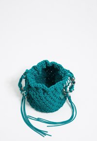 Borsa all'uncinetto color teal con chiusura a coulisse, superficie testurizzata e accenti metallici. Design compatto con manici più lunghi per un trasporto versatile.