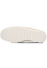 Crème-kleurige sneaker met een geweven bovenwerk van textuur en een witte rubberen zool met horizontale ribbels voor grip.