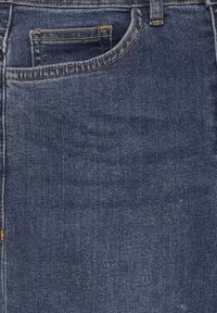 Tessuto di denim blu scuro che mostra la cucitura della tasca frontale e degli anelli della cintura con filo giallo in primo piano.