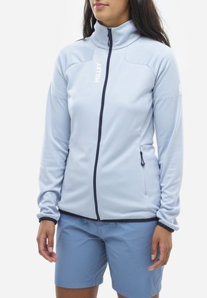 Veste zippée bleu clair avec un col montant, en tissu texturé et accents marine. Elle possède deux poches latérales et un logo sur la poitrine.