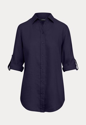 Tumesinine nööbitav lina särk, millel on klassikaline krae, kolmeveerandvarrukad ja kõver serv keeratud varrukatega.