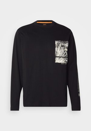 T-shirt nera a maniche lunghe in cotone, con una grafica bianca nella zona della tasca sul petto e testo stampato lungo la manica sinistra.