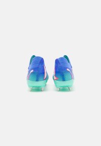Scarpe da atletica blu e verdi con tomaia in mesh testurizzato, linguetta sul tallone e tre tacchetti bianchi alla base. Accenti grafici brillanti sui lati.