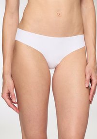 Mutande hipster bianche in cotone con una texture liscia, vita bassa e design senza cuciture, che offrono una copertura minima sulle cosce.