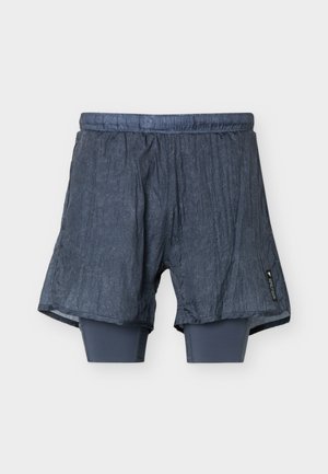 Pantaloncini sportivi grigio scuro con leggings interni aderenti incorporati, fascia elastica in vita e piccola etichetta di tessuto nera sul lato destro.