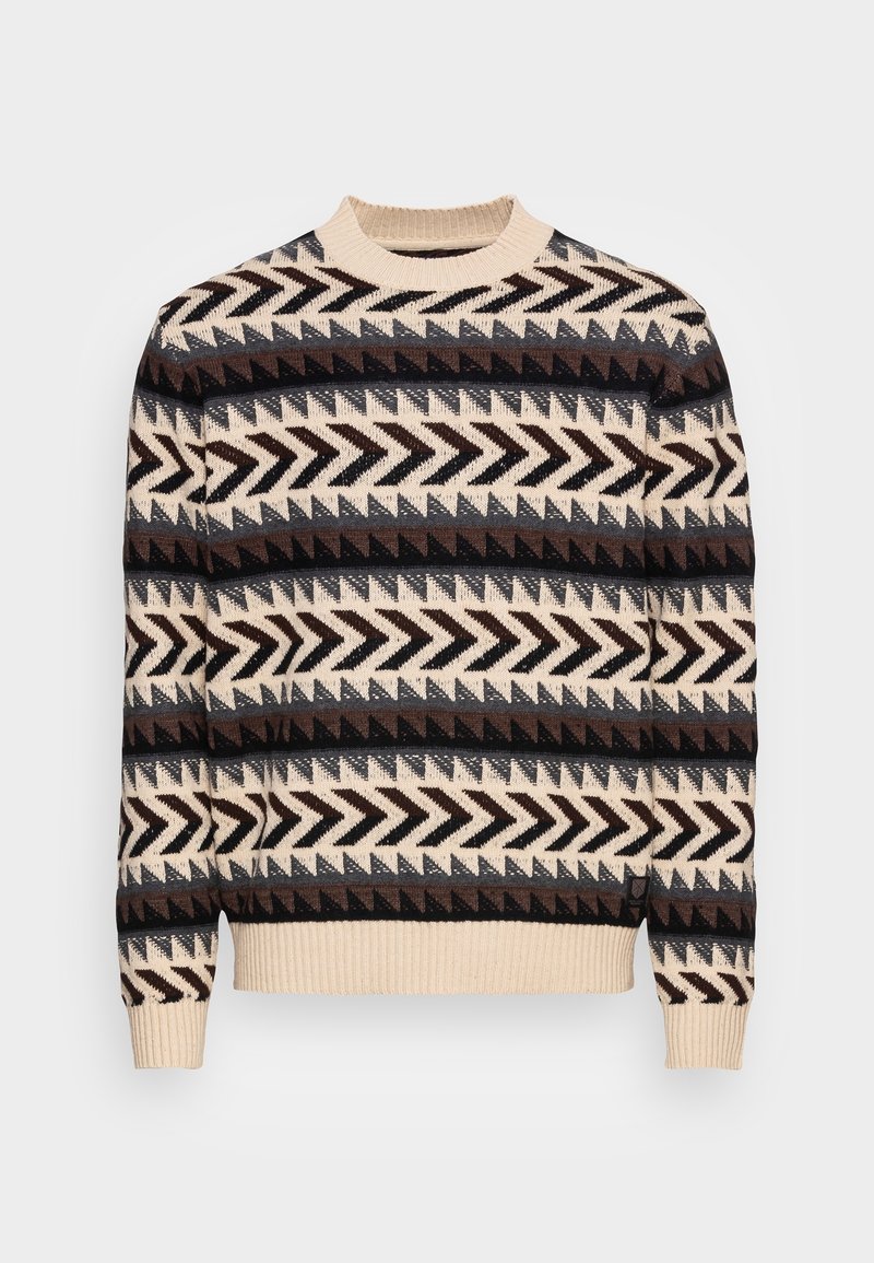 Pull en tricot avec un col rond, motif géométrique en zigzags multicolores marron, beige et noir sur fond crème.