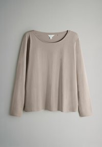 Beżowa koszula z długim rękawem i okrągłym dekoltem, wykonana z miękkiego materiału o gładkiej fakturze. Posiada luźny krój oraz czysty, prosty design.