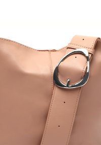 Borsa tote in pelle rosa con una tracolla larga, caratterizzata da una fibbia ovale argento e una superficie liscia. Dettagli delle cuciture visibili lungo i bordi.