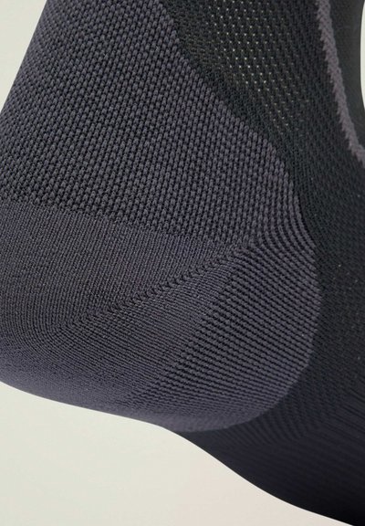 Black sock with ribbed texture, featuring a reinforced heel and smooth upper. Seamless design creates a snug fit for comfort.