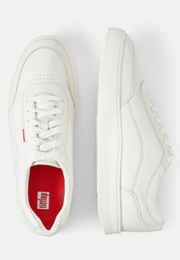 Weiße Leder-Sneaker mit Schnürung an der Vorderseite, perforierten Details an der Zehenpartie und rotem Textilfutter. Mit einer flachen Gummisohle.