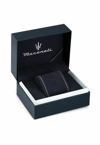 Scatola regalo blu navy con interno bianco, dotata di un morbido cuscinetto simile al suede e del logo Maserati argentato con cuciture bianche.