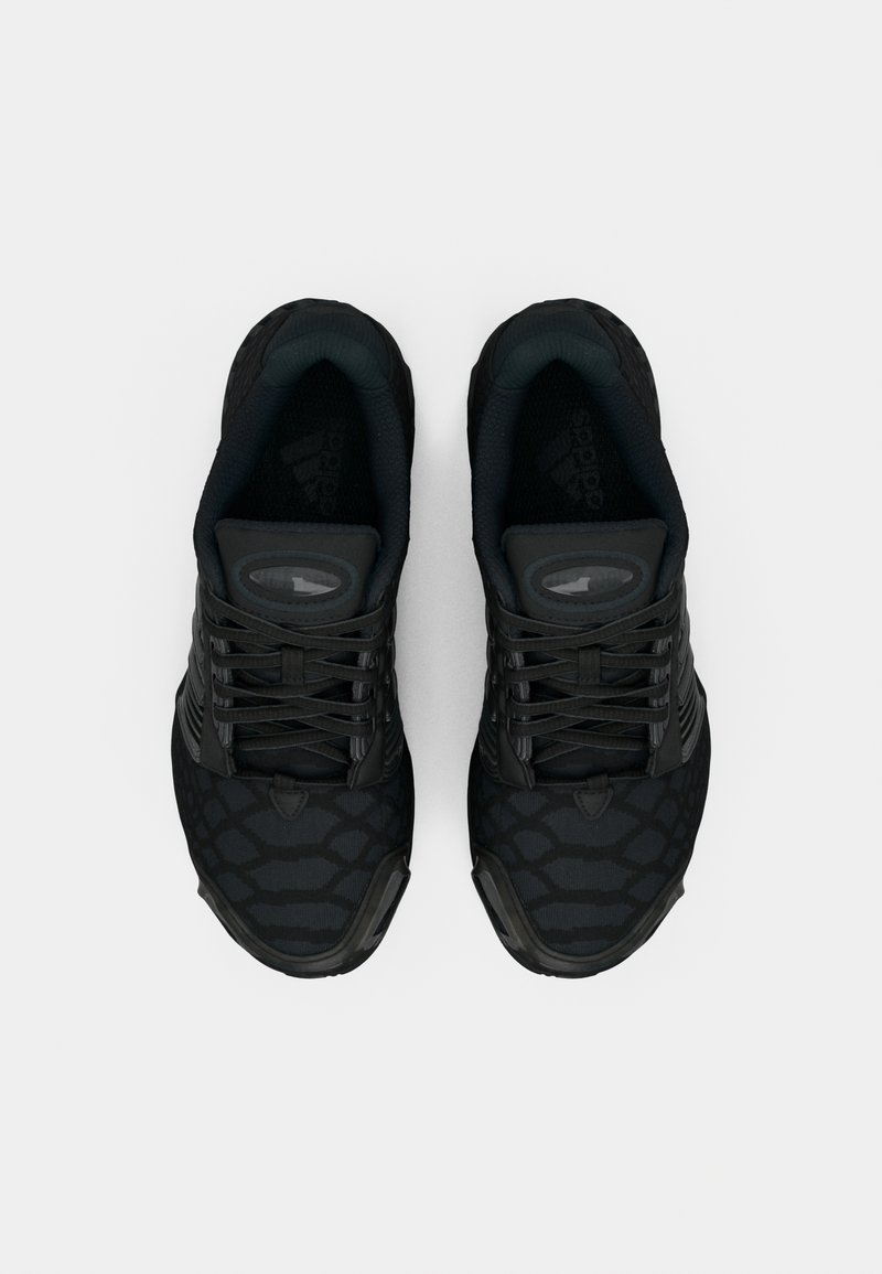 Sorte atletik sko med struktureret overdel med krokodillemønster, runde snørebånd og en polstret sål. Minimalistisk design og farve.