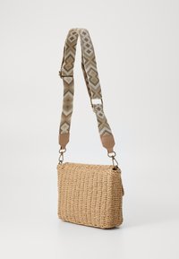 Woven straw shoulder bag with a rectangular shape, featuring a patterned strap in beige and brown, and leather accents.