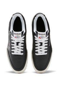 Černé kožené sneakersy s bílými tkaničkami, které mají perforovanou špičku, polstrovaný límec a bílou gumovou podrážku. Logo Reebok na jazyku.