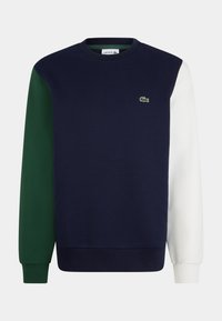 Mörkblå sweatshirt med gröna och vita ärmar. Har en rundad halsringning och en liten broderad logotyp på bröstet. Tillverkad av en bomullsblandning med texturerad yta.