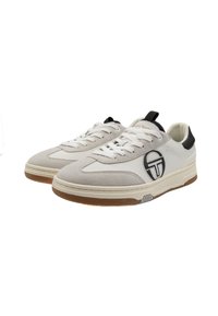 Fény szürke sneaker, velúrból és szintetikus anyagból készült, fehér fűzőkkel és fekete logóval, gumírozott talppal.
