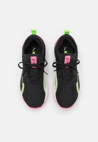 Ett par svarta sportskor med rosa och neongröna detaljer, svarta snören och dragflikar sedd ovanifrån på vit bakgrund.