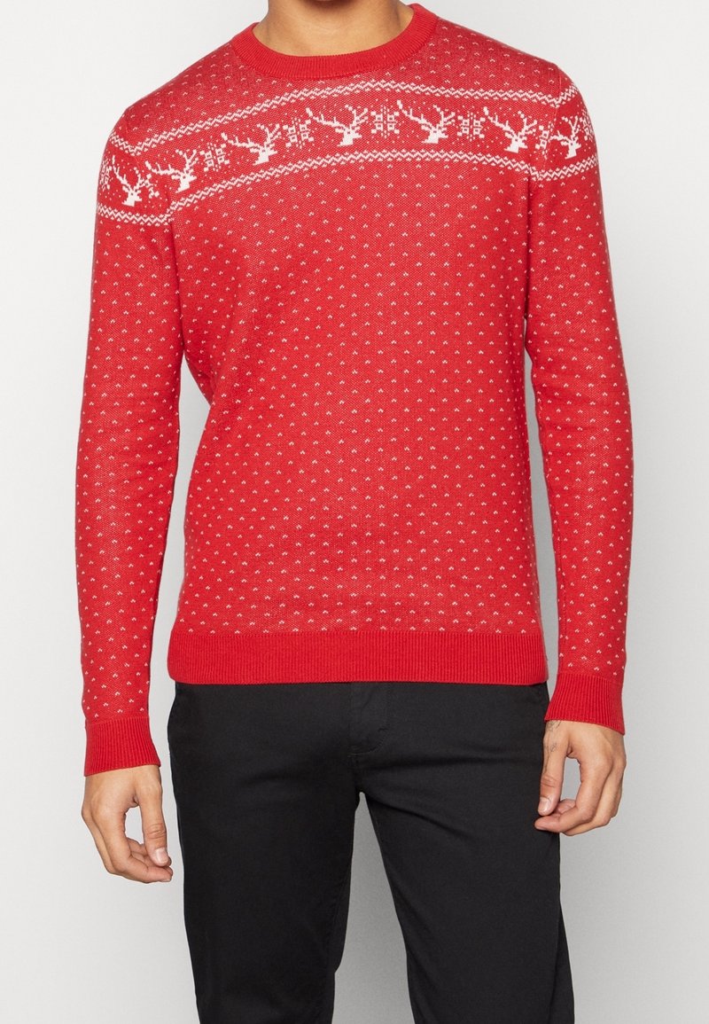 Maglione rosso lavorato a maglia con un motivo di renna bianca e fiocchi di neve sul petto, con polsini e orlo a coste.