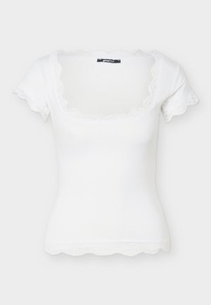 Top blanco ajustado de manga corta con escote cuadrado y delicado ribete de encaje en el escote, las mangas y el dobladillo.