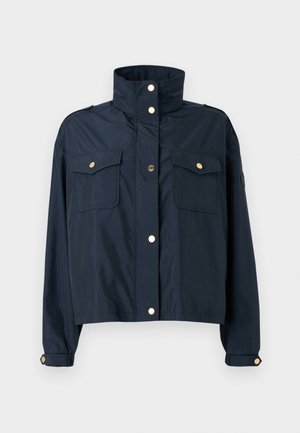 Giacca croppata blu navy con colletto alto, due tasche anteriori, chiusura a pressione e accenti in hardware oro chiaro. Tessuto liscio e leggero.