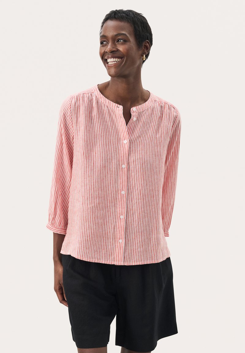 Red and white striped button-up shirt with a round neckline and 3/4 sleeves, paired with black shorts. Lightweight fabric, relaxed fit.