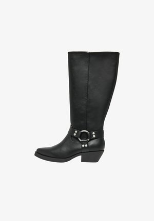 Botte noire en cuir, montante jusqu'au genou, avec un bout pointu, un talon épais, et une large sangle de ceinture ornée d'un anneau en argent et de clous décoratifs.