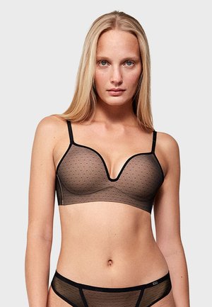 Bralette de malla negra con pequeños lunares, con forma de escote en V, tirantes finos y ribetes en negro contrastante. Diseño simple y moderno.