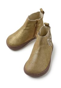 Stivaletti dorati con un accento glitterato, superficie liscia, chiusura con cerniera e suola marrone in contrasto. Design a punta rotonda.