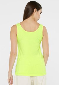 Neon yellow tank top featuring a scoop back design, made of smooth fabric with a fitted silhouette and no visible patterns or accents.