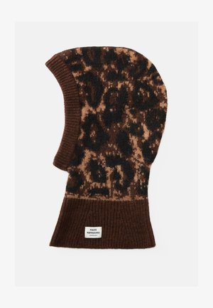Bonnet en tricot marron avec un motif léopard en marron foncé et beige, doté d'un ourlet côtelé et d'une étiquette à la base.