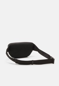 Musta olkalaukku, jossa on kuvioitu pinta ja geometrinen kuvio, säädettävä hihna ja jämäkkä muoto.