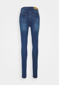 Jeans skinny em denim azul escuro, com uma cintura alta, dois bolsos traseiros e uma textura suave. Design minimalista sem embelezamentos visíveis.