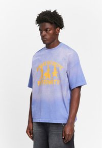 Lilla gradient kortermet t-skjorte med gul tekst "CREATIVE DEPT. ETERNITY" og grafikk, laget av myk bomullsstoff.