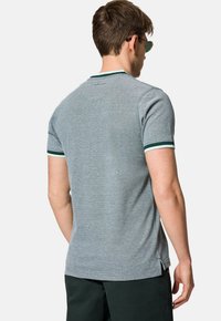 Szary polo z krótkim rękawem, wykonane z fakturowanej tkaniny, z zielono-białymi paskami na kołnierzyku i mankietach. Logo z tyłu.