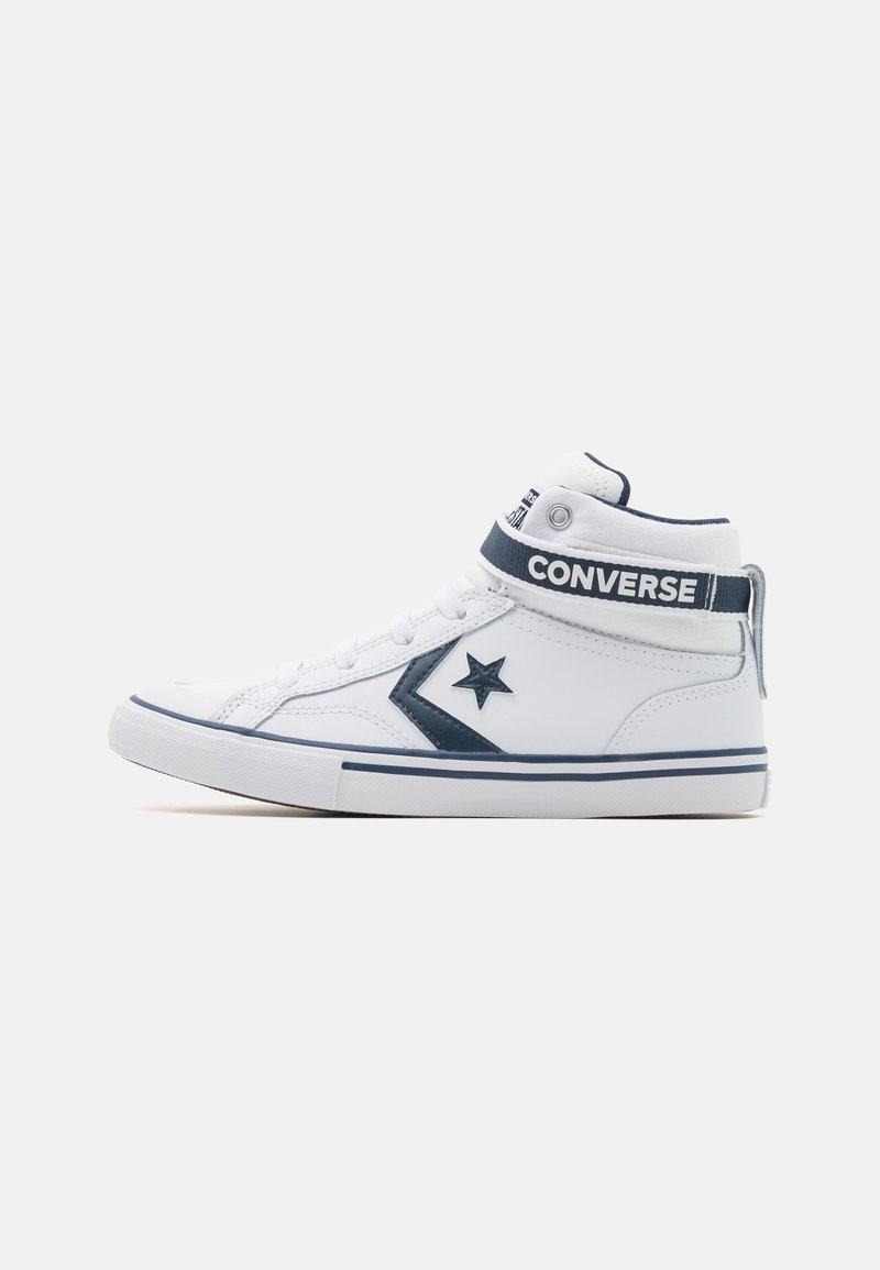 Baskets montantes blanches Converse avec étoile chevron bleu marine, bride à la cheville et semelle en caoutchouc, vues de côté sur fond uni.