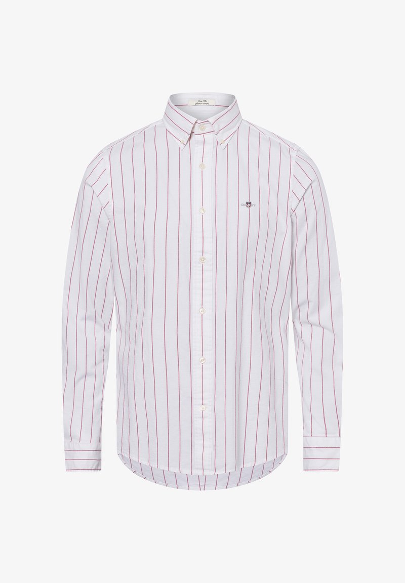 Weißes Hemd mit dünnen roten vertikalen Streifen, langen Ärmeln und abgerundetem Saum. Verfügt über ein kleines Logo auf der linken Brust. Aus Baumwollmaterial.